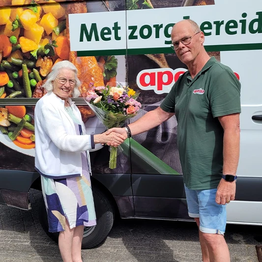 Bezorger van apetito overhandigt bos bloemen aan mevrouw De Jong - Veenstra