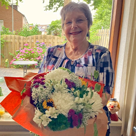 Mevrouw Smeets met bos bloemen