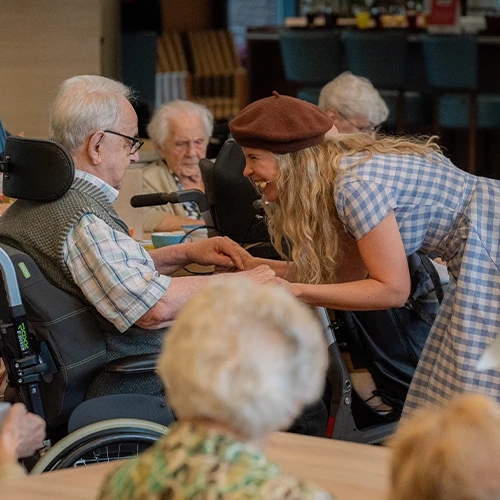Astrid Nijssen hand in hand met senior man in rolstoel