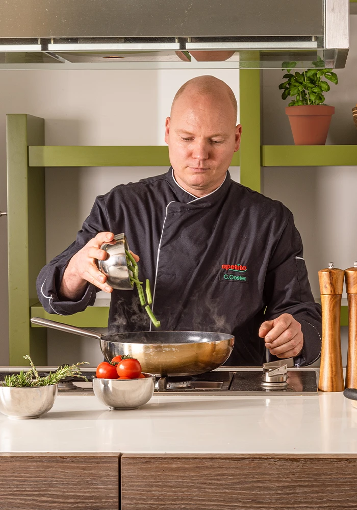 Chefkok Chris gooit sperziebonen in een pan in een moderne keuken.