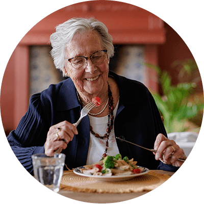 Vrouw eet haar maaltijd aan tafel